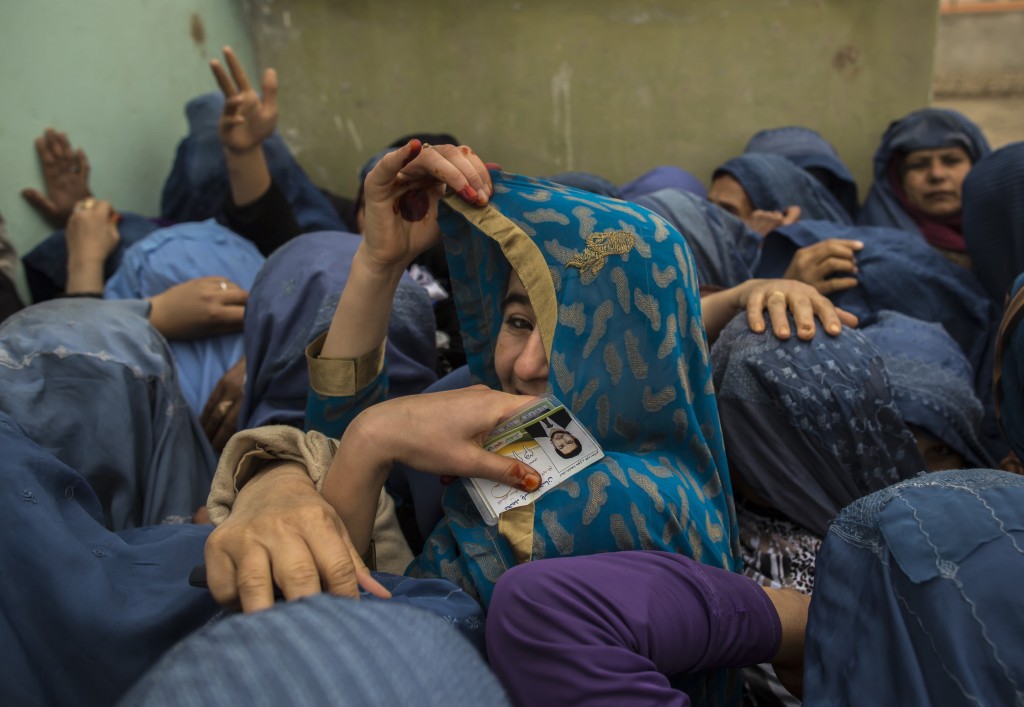 Afghan women wait to cast their ballots at a polling station in Mazar-i-sharif